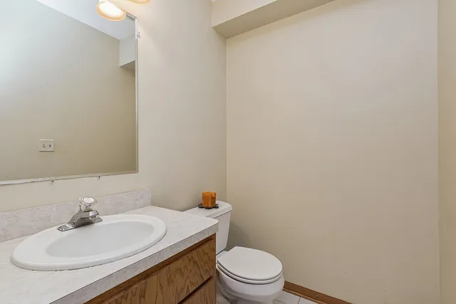 a bathroom with a toilet a sink and mirror