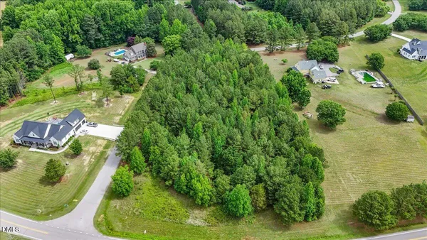an aerial view of residential house with outdoor space and trees all around