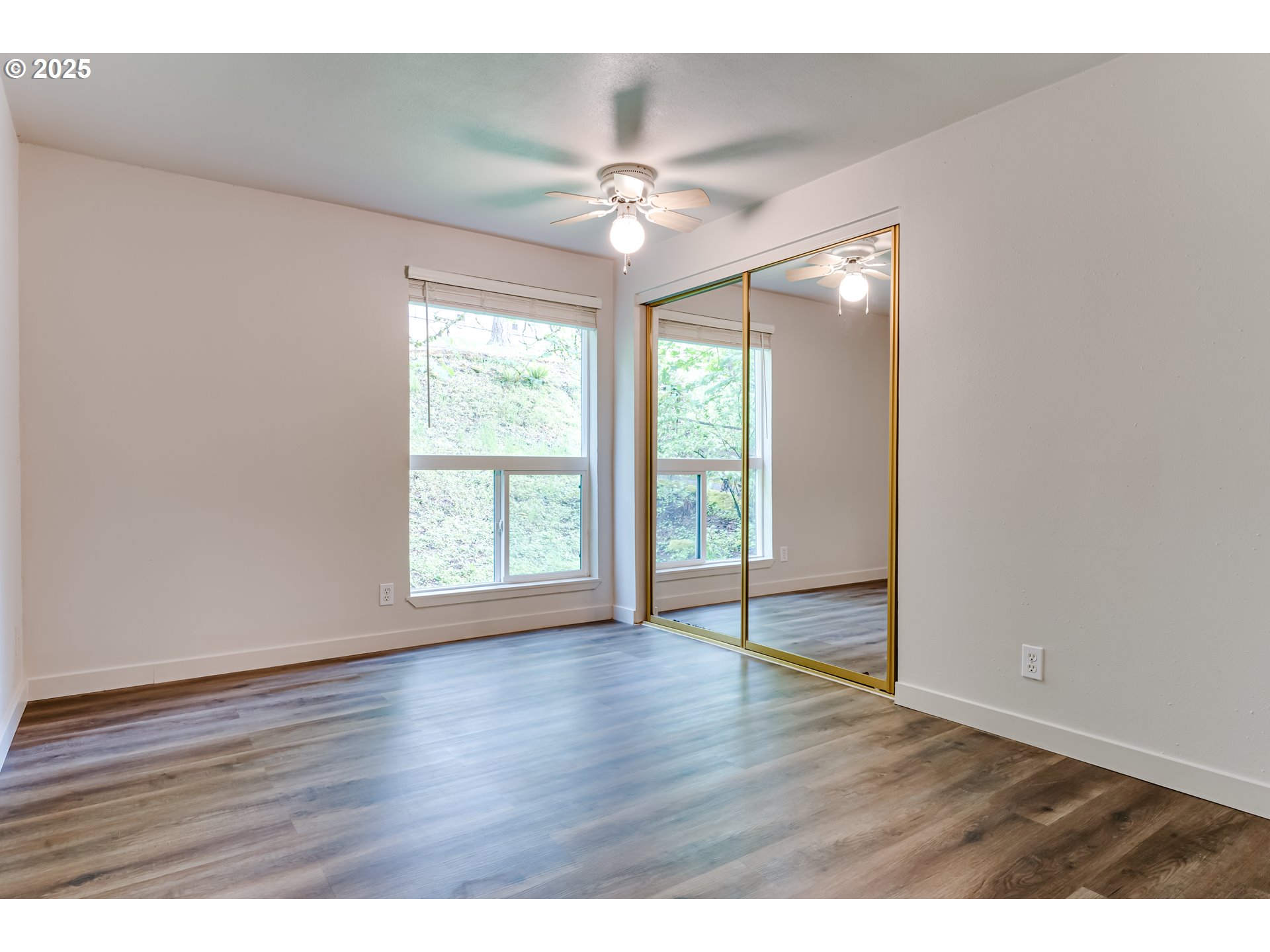 418 Stonewood Drive Eugene, OR 97405 - Photo 13 of 36 a view of an empty room with wooden floor and a window