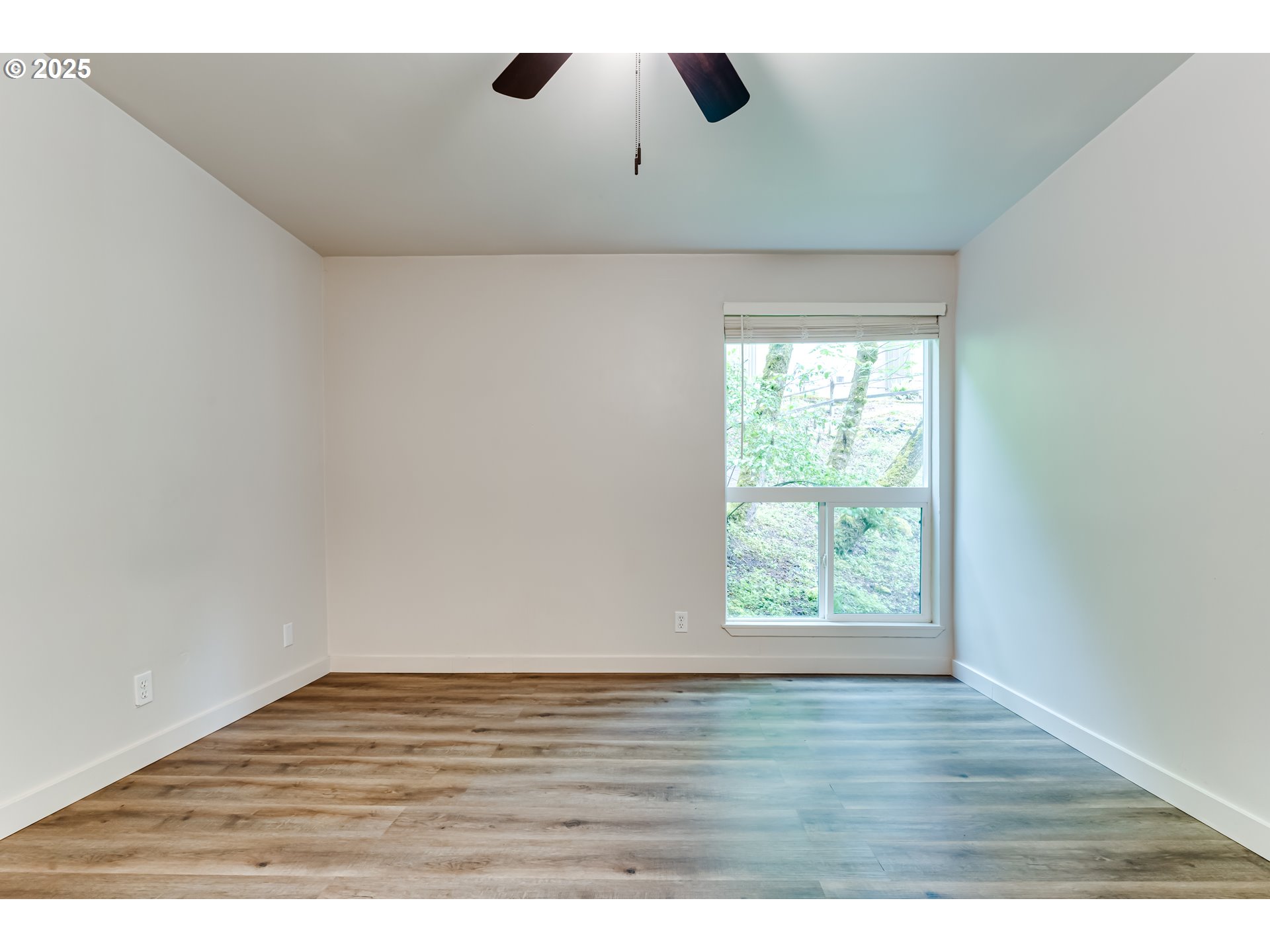 418 Stonewood Drive Eugene, OR 97405 - Photo 18 of 36 an empty room with wooden floor and windows