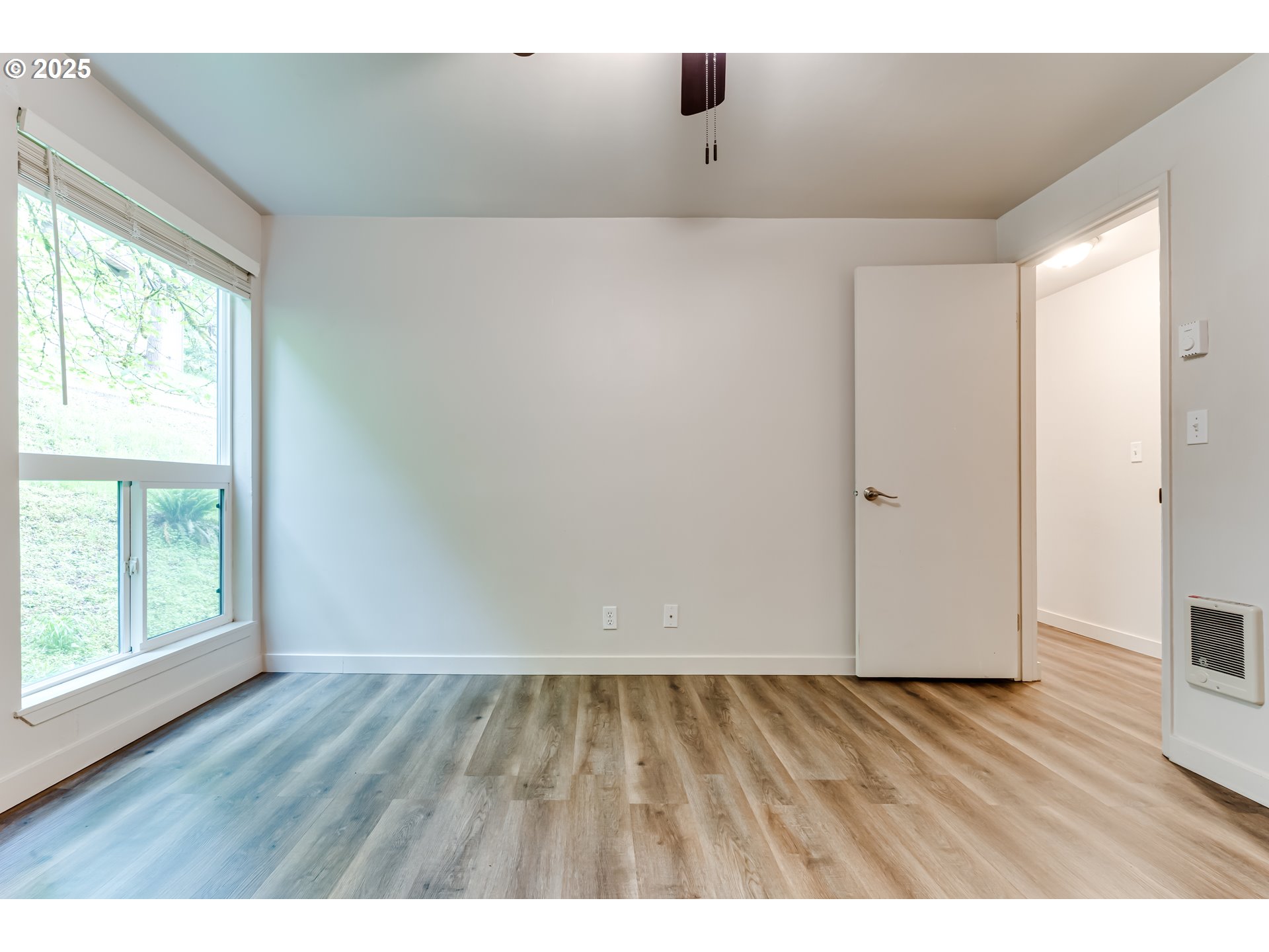 418 Stonewood Drive Eugene, OR 97405 - Photo 19 of 36 a view of an empty room with wooden floor and a window