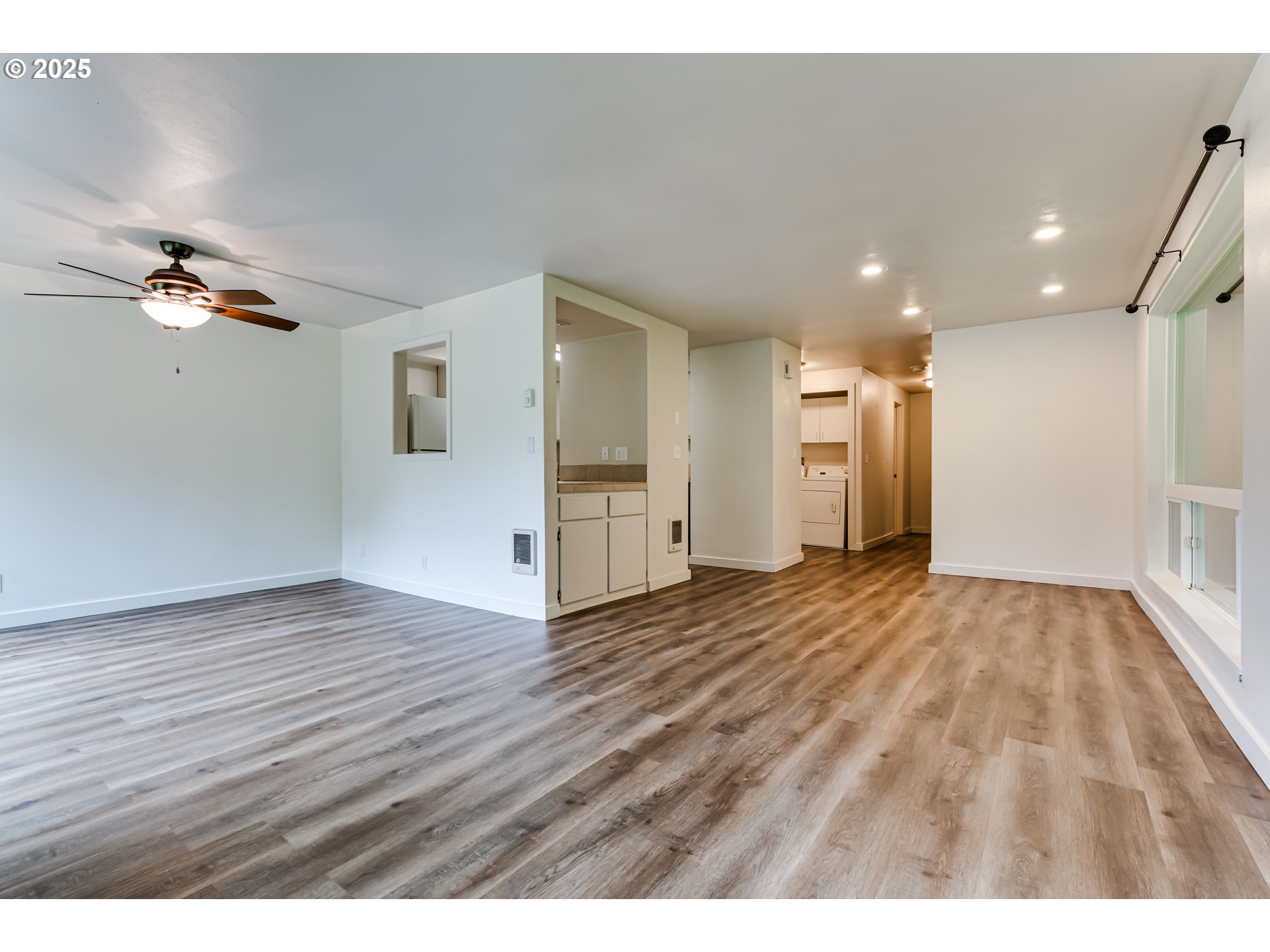 418 Stonewood Drive Eugene, OR 97405 - Photo 4 of 36 a view of an empty room and a kitchen with wooden floor