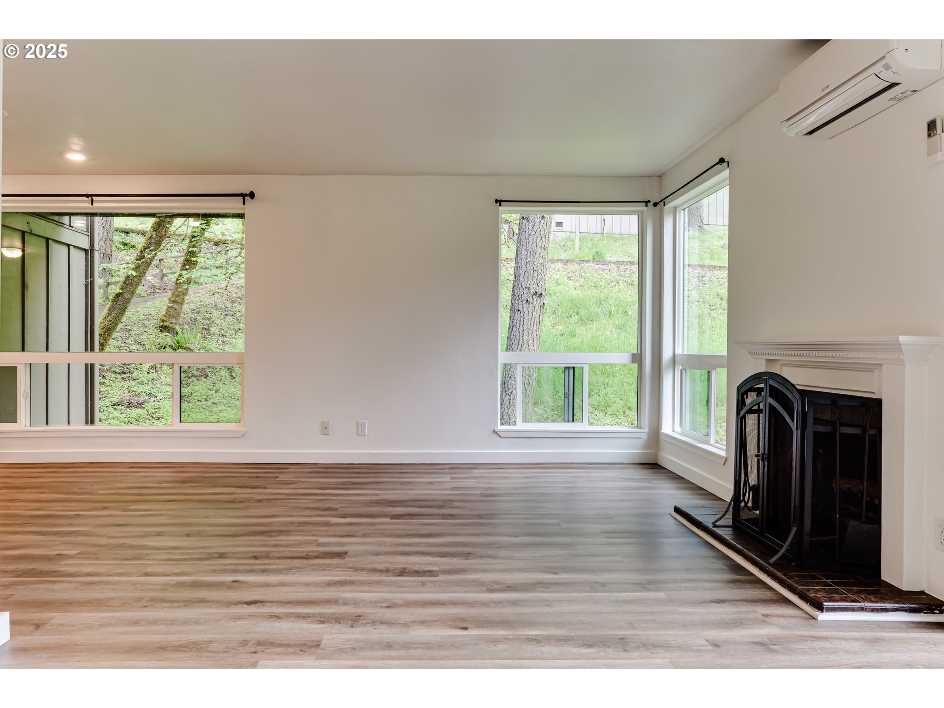 418 Stonewood Drive Eugene, OR 97405 - Photo 10 of 36 a view of an empty room with wooden floor and a window