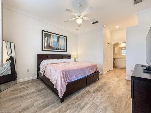 a spacious bedroom with a bed and a chandelier
