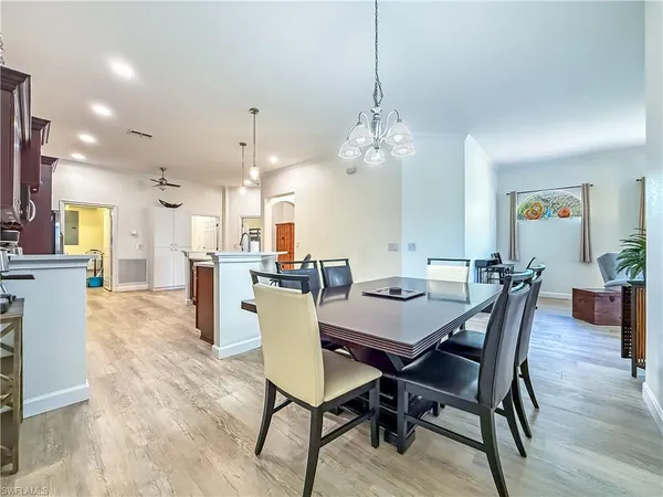 a view of a dining room and livingroom with furniture wooden floor a chandelier