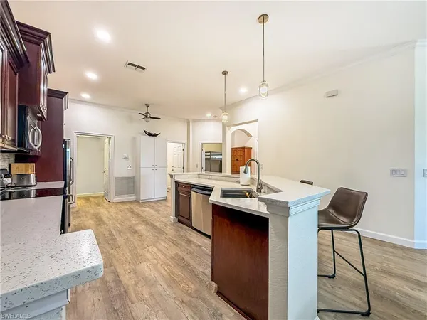 a kitchen with stainless steel appliances granite countertop a sink a stove and a wooden floors