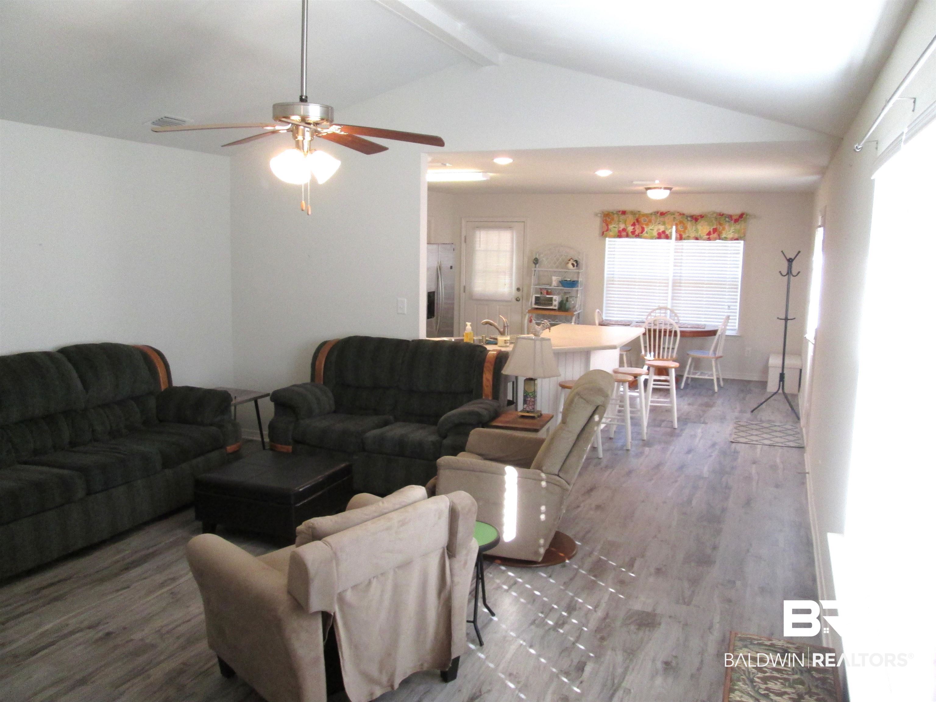 530 Brethren Church Road Fruitdale, AL 36539 - Photo 4 of 24 Living room featuring vaulted ceiling with beams, ceiling fan, and wood-type flooring