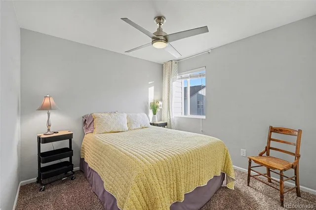 a bedroom with a bed a chandelier and a window