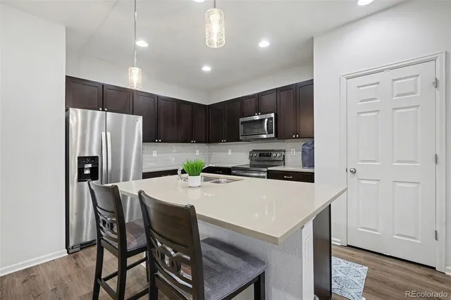 a kitchen with kitchen island a refrigerator stove microwave and cabinets