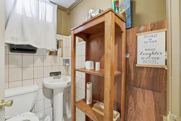 a bathroom with a toilet sink and mirror