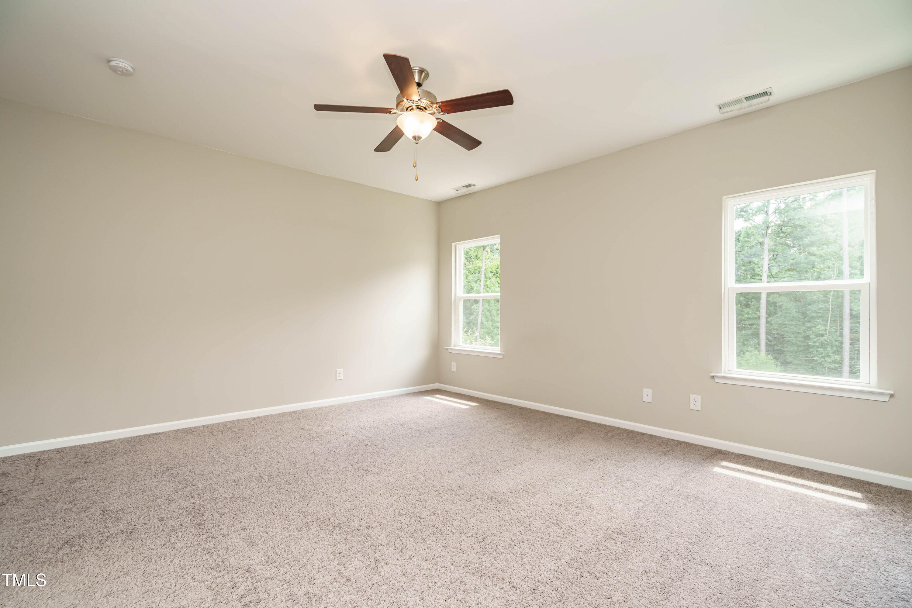 6333 Grace Lily Drive Raleigh, NC 27607 - Photo 14 of 26 an empty room with a window and a fan