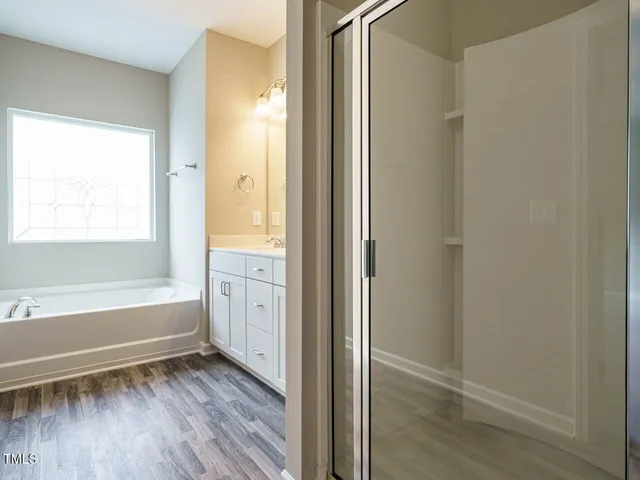a view of bathroom with bathtub and wooden floor