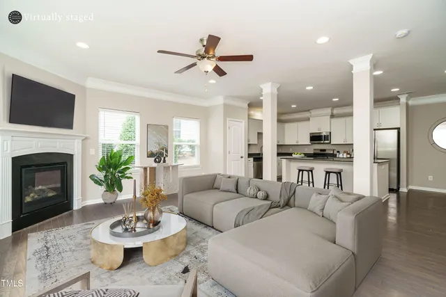 a living room with furniture kitchen view and a fireplace