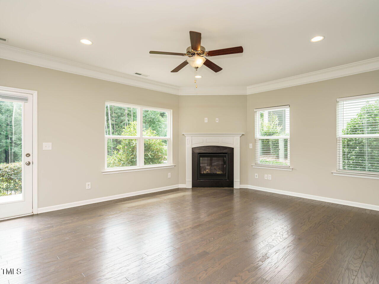 6333 Grace Lily Drive Raleigh, NC 27607 - Photo 7 of 26 an empty room with wooden floor fan and windows