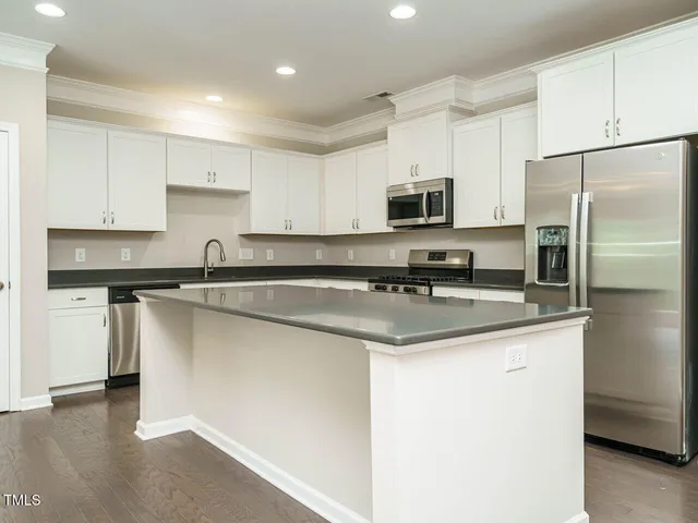 a kitchen with stainless steel appliances a sink stove refrigerator and cabinets