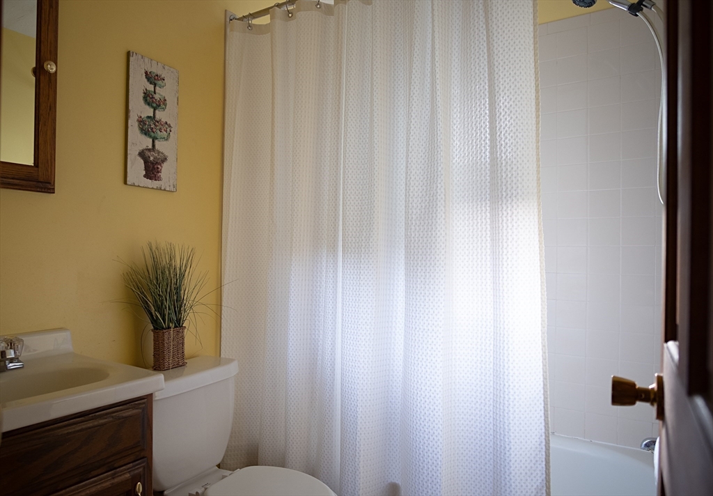16 Arlington Road Natick, MA 01760 - Photo 13 of 34 a bathroom with a toilet and a shower curtain