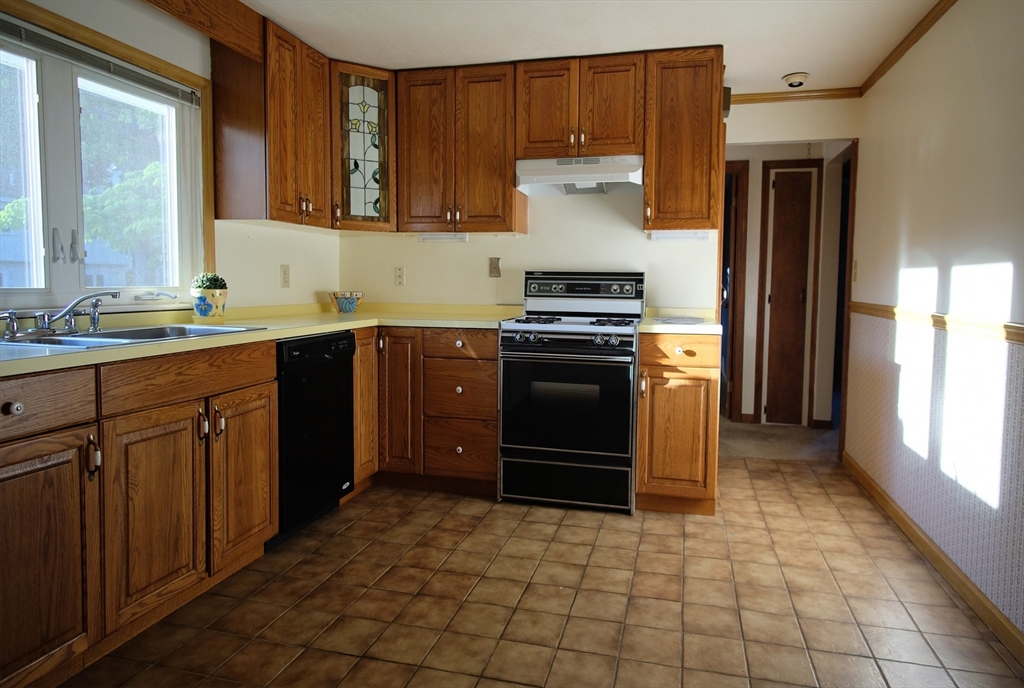 16 Arlington Road Natick, MA 01760 - Photo 9 of 34 a kitchen with stainless steel appliances granite countertop a stove a sink and a refrigerator