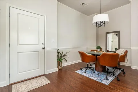 a dining room with furniture a chandelier and wooden floor