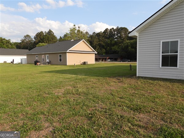 5915 Rye Patch Road Ludowici, GA 31316 - Photo 14 of 25 a front view of a house with a yard