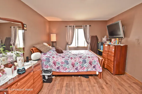 a bedroom with a bed and wooden floor