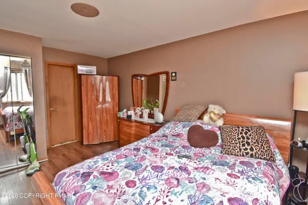 a bedroom with a bed and wooden floor