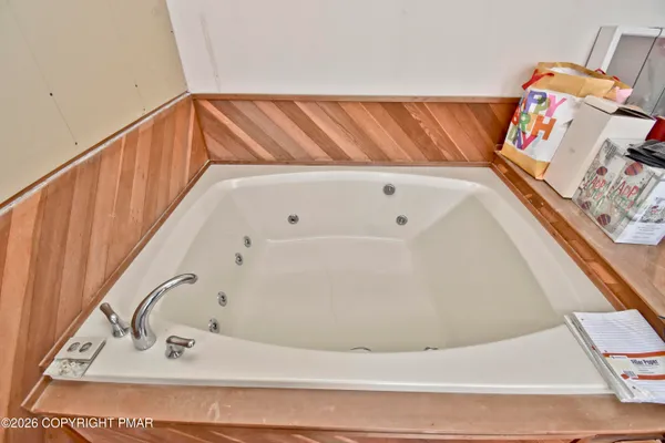 a bed sitting in a bedroom next to a window with tv