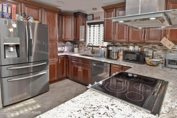a kitchen with stainless steel appliances granite countertop a sink stove and refrigerator