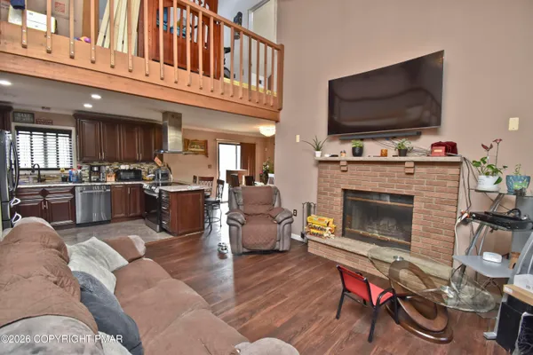 a living room with furniture a flat screen tv and a fireplace