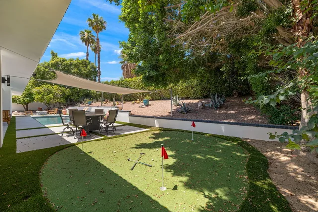 a view of a patio with dining table and chairs under an umbrella