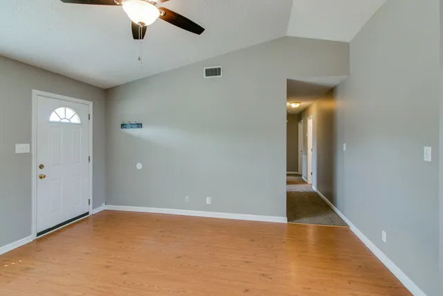 an empty room with fan and entrance