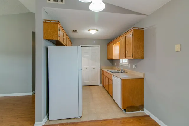 a kitchen with a sink cabinets and wooden floor