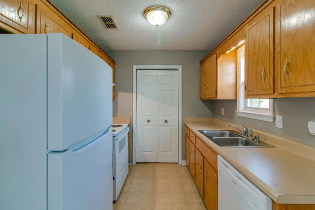 a kitchen with a sink a refrigerator and window