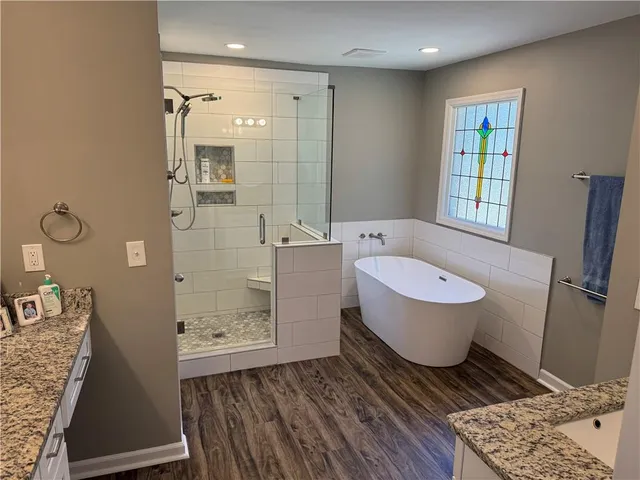 a bathroom with a granite countertop double vanity sink and a mirror