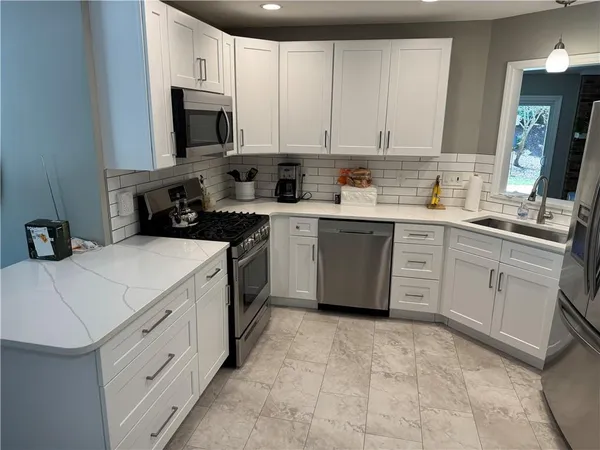 a kitchen with stainless steel appliances a refrigerator sink and microwave