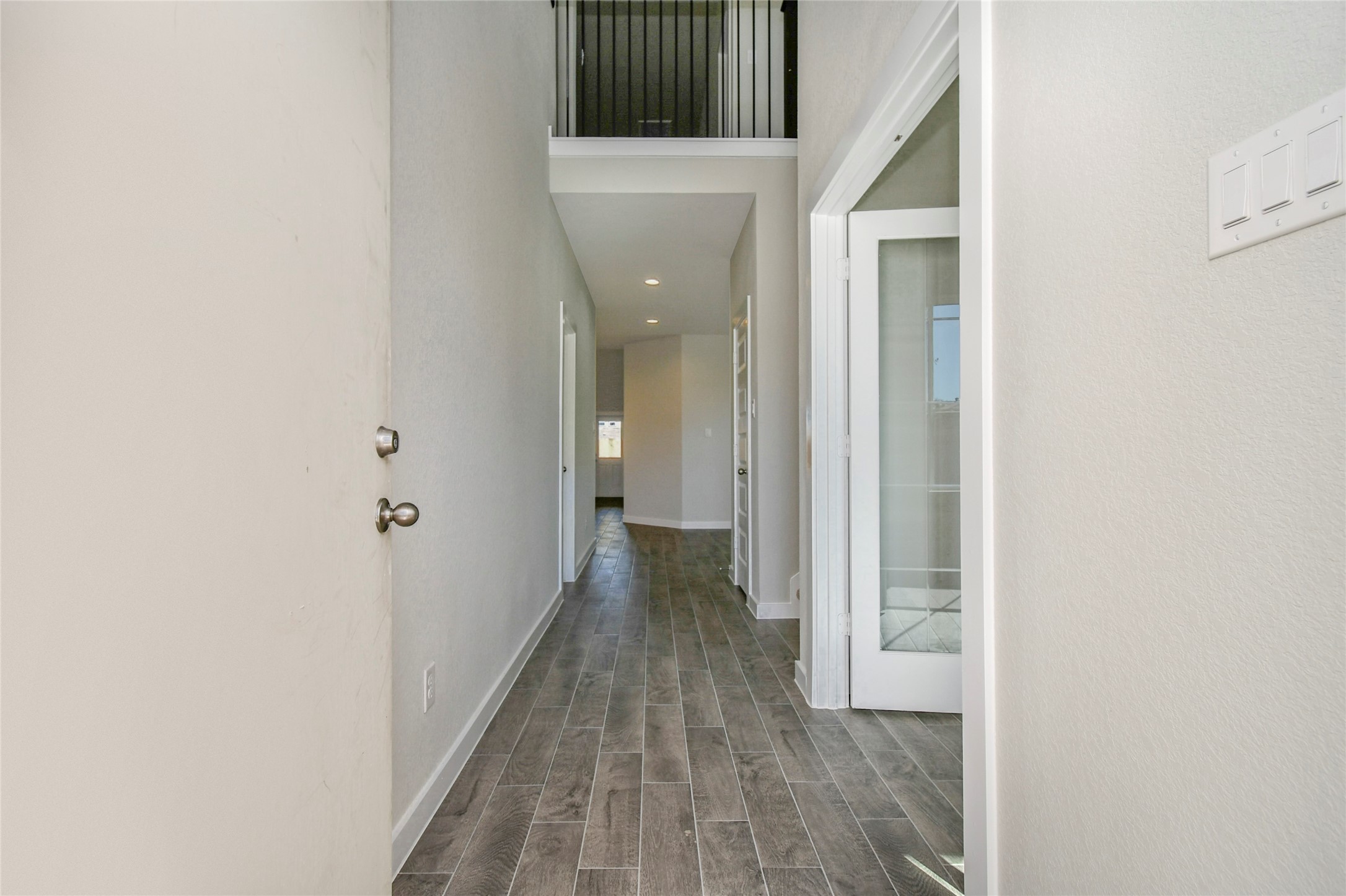 15111 Statice Trail Houston, TX 77044 - Photo 9 of 35 Indulge in luxury as you step into the threshold of this breathtaking home. The grand entrance beckons with its soaring ceilings, adorned with elegant wood-look tile flooring featuring sleek oversized baseboards. Sample photo of completed home with similar floor plan. Actual colors and selections may vary.