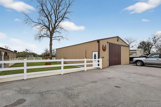 a view of a house with a yard and large trees