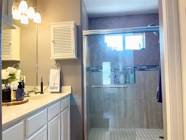 a bathroom with a sink a mirror and a shower