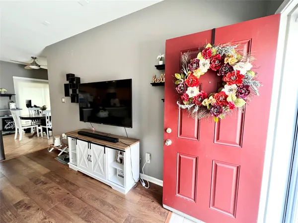 a living room with stainless steel appliances furniture and a flat screen tv