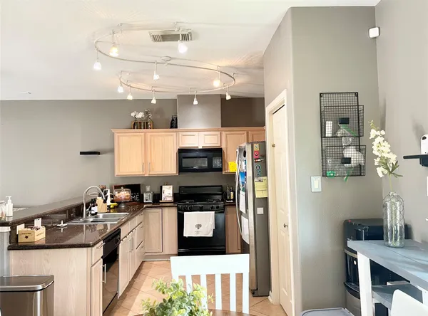 a kitchen with stainless steel appliances kitchen island granite countertop a refrigerator and a stove top oven
