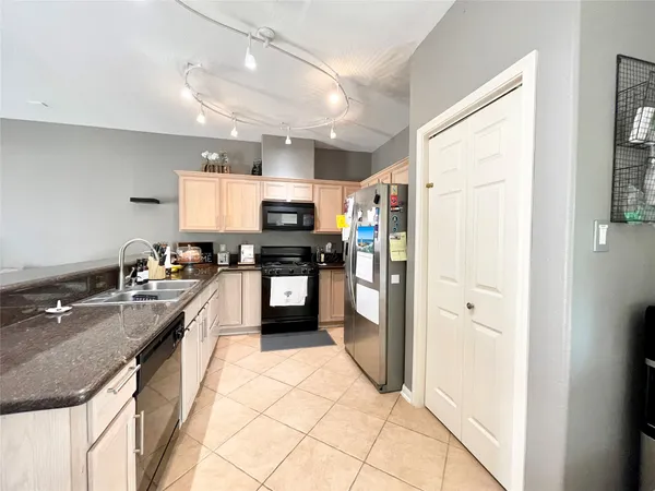 a kitchen with stainless steel appliances granite countertop a refrigerator a sink dishwasher a stove with wooden cabinets