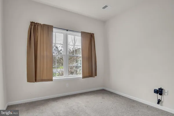 an empty room with walk in closet with empty racks