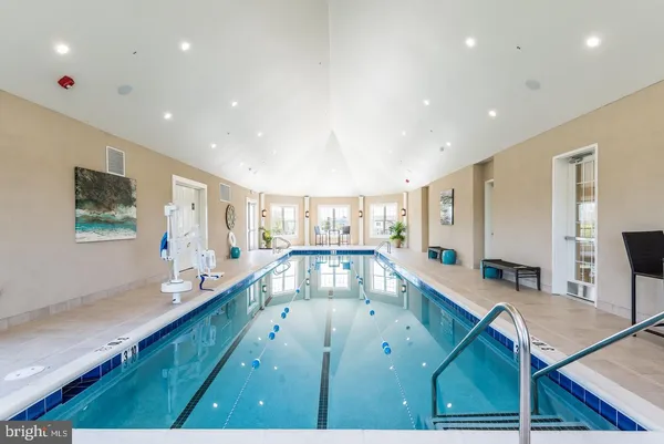 a dining hall with couches a table and chairs with wooden floor