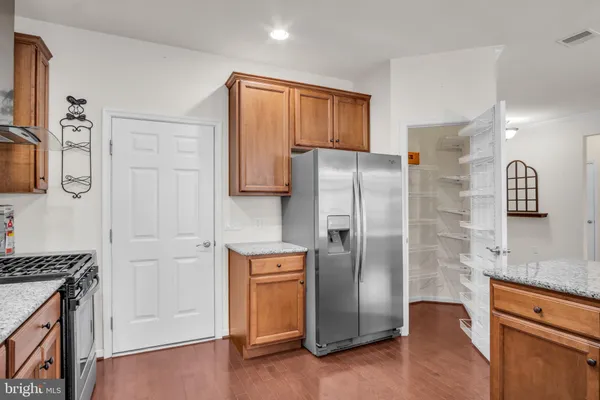 a kitchen with a stove and a wooden floor
