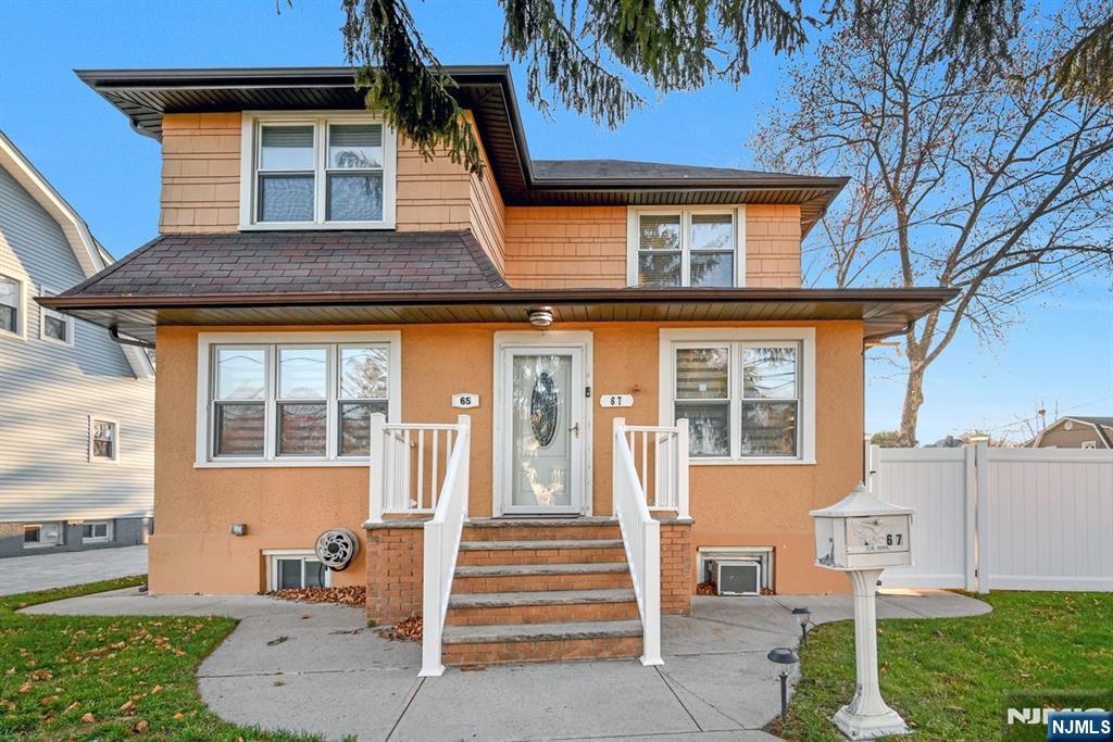 a front view of a house with a garden and plants