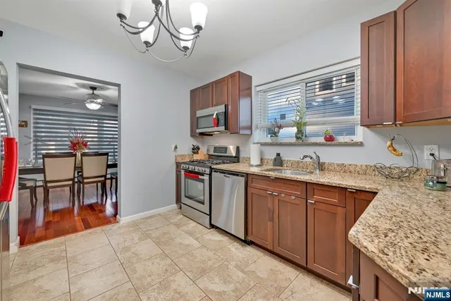 a kitchen with stainless steel appliances granite countertop a sink stove and cabinets