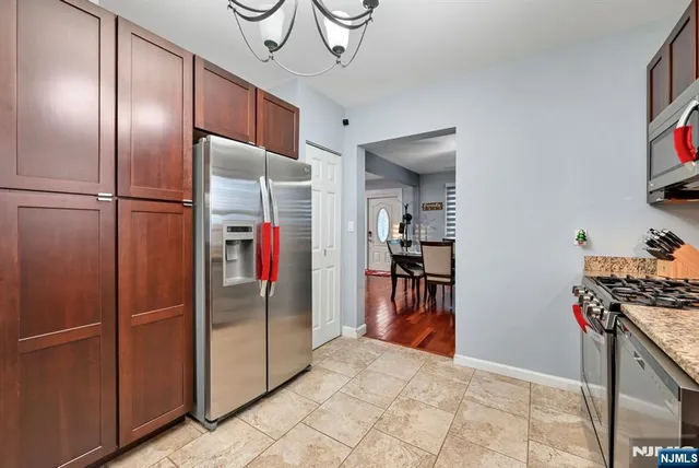 a kitchen with stainless steel appliances granite countertop a refrigerator and a sink