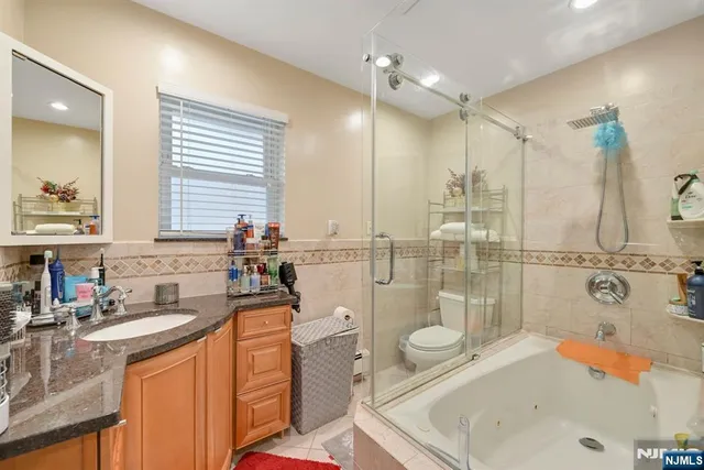 a bathroom with a tub sink toilet and mirror