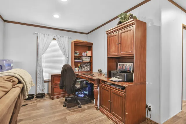 a view of a workspace with furniture and a window