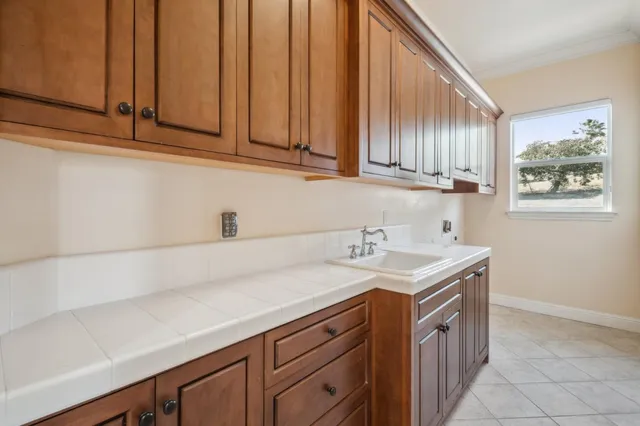 a spacious bathroom with a granite countertop double vanity sink a mirror and a bathtub