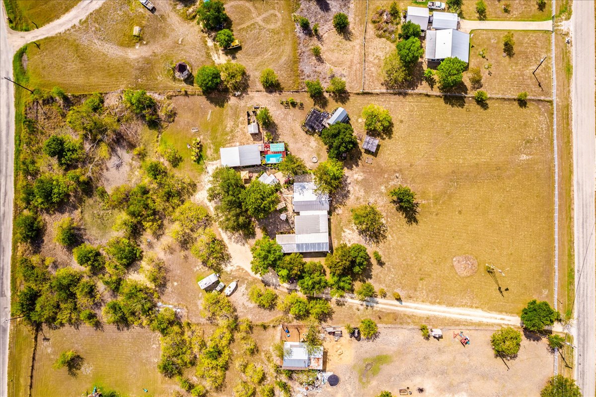 3.33 acres - A sweeping aerial view reveals the expansive acreage, mature trees, and outbuildings of this property.